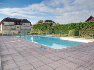 a swimming pool in a yard next to a building at Studio Bowie with shared pool by Interhome in De Haan