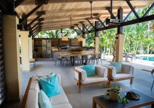 uma sala de estar com sofás e uma mesa de jantar em Hotel La Finca Buritaca by DOT Premium em Buritaca