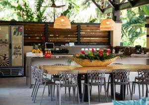 a wooden table with chairs and a bowl of flowers on it at Gardenia Springs - La Finca Buritaca in Buritaca