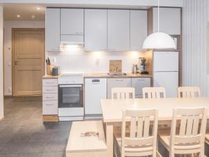 a kitchen with white cabinets and a table and chairs at Holiday Home Rukatonttu d 15 by Interhome in Ruka