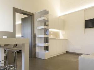 Apartment Tipologia Bilo 04 pax by Interhome في فلورنسا: مطبخ مع دواليب بيضاء وطاولة ومقعد