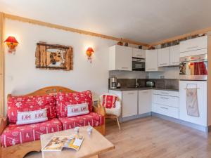 sala de estar con sofá rojo y cocina en Apartment Le Bec Rouge-7 by Interhome, en Tignes