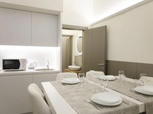 una sala da pranzo con tavolo, piatti e bicchieri da vino di Apartment Tipologia Trilo 06 pax by Interhome a Firenze