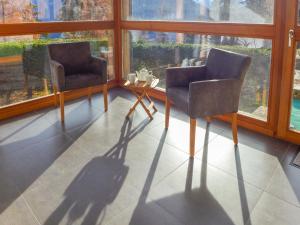2 stoelen en een tafel in een kamer met ramen bij Apartment Haimavati by Interhome in Verbier