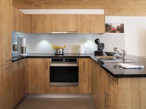una cucina con armadi in legno e piano cottura. di Apartment Les Savolaires 4 by Interhome a Gryon