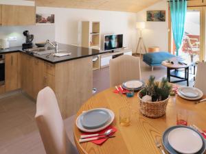 a kitchen and dining room with a wooden table with chairs at Apartment Les Savolaires 4 by Interhome in Gryon