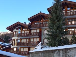 een groot gebouw met een boom ervoor bij Apartment Shangri La by Interhome in Zermatt