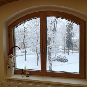 een raam met uitzicht op een met sneeuw bedekte tuin bij Yes Dream apartment in Jeseník