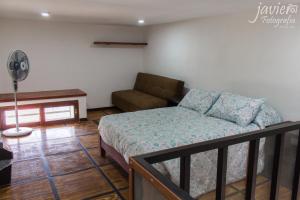 a bedroom with a bed and a couch at LOFTS en Cuernavaca con alberca climatizada in Cuernavaca +28 photos
