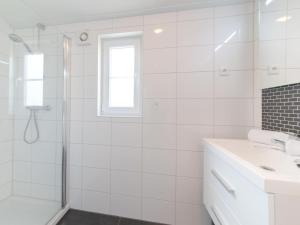 a white bathroom with a shower and a sink at Holiday Home Park Kerlinga-20 by Interhome in Bredene