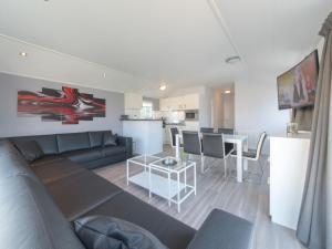 a living room and kitchen with a couch and a table at Holiday Home Park Kerlinga-20 by Interhome in Bredene