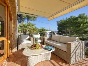a patio with wicker furniture and a table with a bowl of fruit at Villa Monte Feliz by Interhome in Jávea