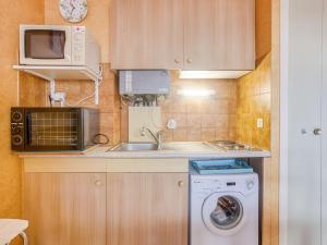 cocina pequeña con lavadora y microondas en Apartment Résidence Les Béniguets by Interhome, en Quiberon