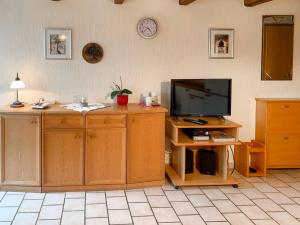 a living room with a flat screen tv and wooden cabinets at Apartment Peters-2 by Interhome in Barkholt