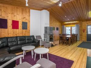 ein Wohnzimmer mit einer schwarzen Ledercouch und einem Tisch in der Unterkunft Holiday Home Karhunpesä b by Interhome in Kotila