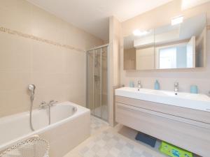 ein Badezimmer mit einer Badewanne und einem Waschbecken in der Unterkunft Apartment Paul's parklane by Interhome in Bredene