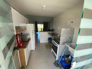 a kitchen with a white refrigerator and a sink at Apt no Cond. Resort Villa das Águas in Atalaia