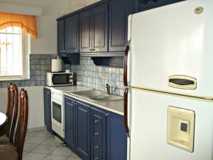 a kitchen with blue cabinets and a white refrigerator at Kristallia Rooms in Monastiraki