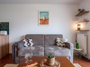 a living room with a couch and a table at Studio Village de Légenèse-4 by Interhome in Carnac
