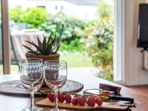 a table with two wine glasses and a plate of tomatoes at Studio Village de Légenèse-4 by Interhome in Carnac +14 photos