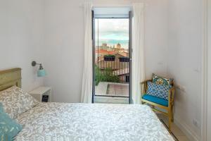Un dormitorio con una cama y una ventana y una silla. en Casa do Re, en Catania