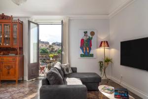 een woonkamer met een bank en een flatscreen-tv bij Casa do Re in Catania