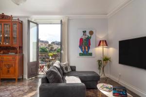 Una sala de estar con un sofá y un televisor de pantalla plana. en Casa do Re, en Catania
