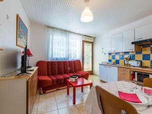 ein Wohnzimmer mit einem roten Sofa und einem Tisch in der Unterkunft Studio Le Grec by Interhome in Le Grau-du-Roi