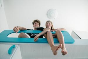 a man and a woman sitting on a diving board at Villaggio Mietta in Castiglioncello