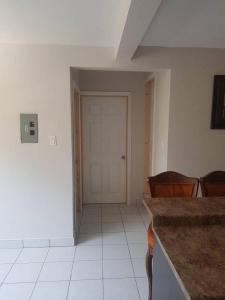 a room with a hallway with a door and chairs at Otay 2 bedroom condo in Tijuana