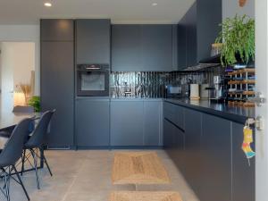 a kitchen with blue cabinets and a table with chairs at Apartment Mira-5 by Interhome in Umag