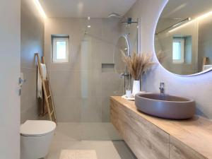 a bathroom with a sink and a toilet and a mirror at Apartment Penthouse Mira by Interhome in Umag