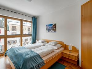 two beds in a room with a large window at Apartment Papa Joe's Kuschelappartements-2 by Interhome in Schladming