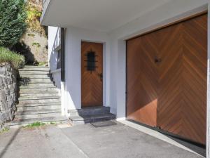 uma porta de garagem de madeira numa casa com escadas em Chalet Astrantia by Interhome em Gryon