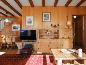 a living room with a television and wooden walls at Chalet Astrantia by Interhome in Gryon