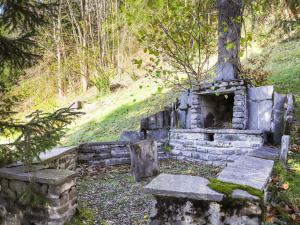 um velho forno de pedra no meio de uma floresta em Chalet Astrantia by Interhome em Gryon
