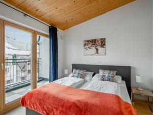 a bedroom with a large bed and a balcony at Apartment Papa Joe's Kuschelappartements-3 by Interhome in Schladming
