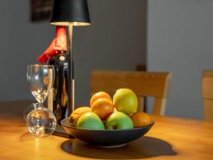 a bowl of fruit on a table with a bottle of wine at Apartment Papa Joe's Kuschelappartements-1 by Interhome in Schladming