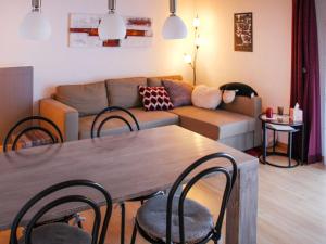 a living room with a couch and a table with chairs at Apartment Grande-Ourse 2 pièces 1027 by Interhome in Moleson