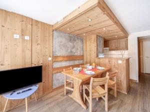 a wooden dining room with a table and a tv at Studio Palafour - Le Lac-4 by Interhome in Tignes