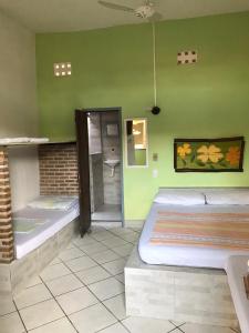 2 camas en una habitación con paredes verdes en Toca da Rapoza en Salvador