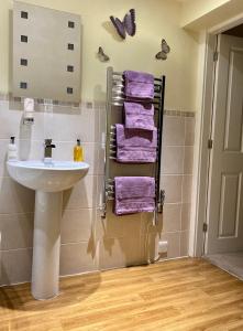 a bathroom with a sink and purple towels at Stiles of Ambleside in Ambleside