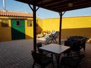 un patio con mesa y sillas y un edificio en Arroyo Milano Casa Rural, en Maello