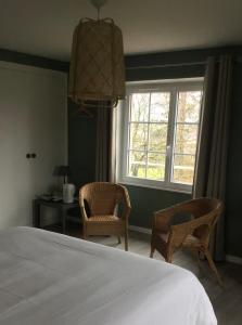 1 dormitorio con 1 cama, 2 sillas y ventana en Chambres d'hôtes La Maison d'Après en Charolles