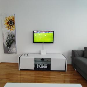 a living room with a flat screen tv on a white wall at Stan na dan Bijeljina Niki garaža,wifi in Bijeljina