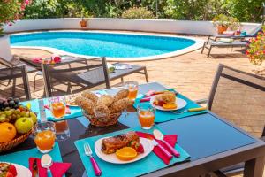 - une table avec de la nourriture à côté de la piscine dans l'établissement Villa Sunshine by Algarve Vacation, à Armação de Pêra