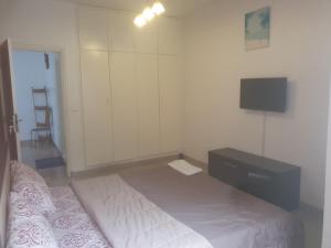 a bedroom with a bed and a dresser and a television at Appart Sly Abidjan in Cocody