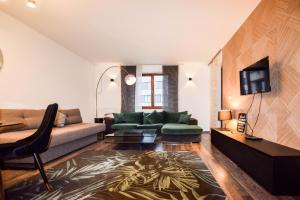 salon z kanapą i telewizorem w obiekcie Apartament z widokiem na Wawel w centrum miasta w Krakowie