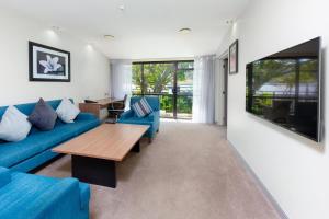 a living room with a blue couch and a table at Holiday Inn Auckland Airport by IHG in Auckland