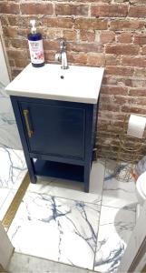 a blue and white sink in front of a brick wall at Harlem Brownstone in New York